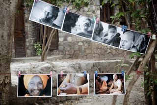 Black and white portrait photos pegged on lines between trees. Rishikesh, India, 2010.