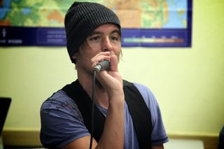 A young man in a grey beanie sings into a microphone. Brandenburg, Germany, 2010.