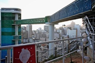 A terrace above the city with a walkway bridge and a hand-painted alien sign on the railing. Brazil, 2012.