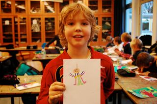A large group of children hold up their alien drawings together. Germany, 2011.