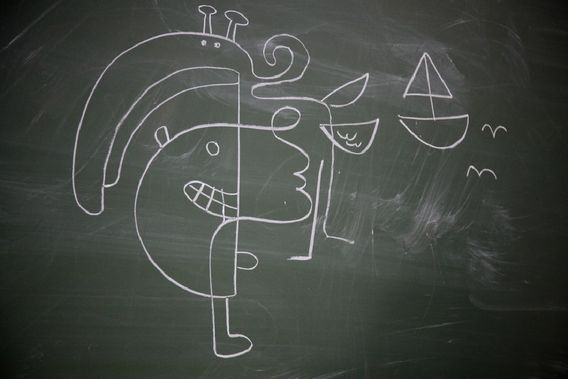A chalk drawing on a blackboard: a face split into two halves, a sailboat and a bird.