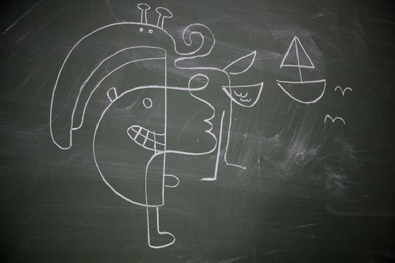 A chalk drawing on a blackboard: a face split into two halves, a sailboat and a bird.