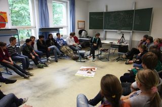 Students sit in a circle of chairs in a classroom. Brandenburg, Germany, 2010.