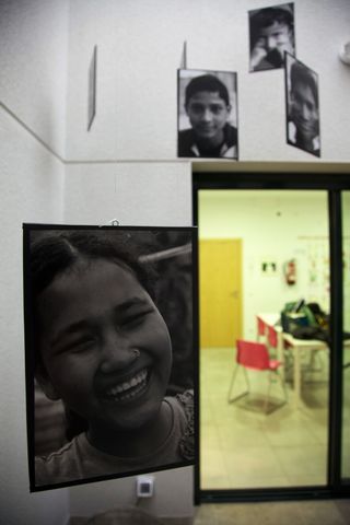 A large black and white portrait of a smiling girl hangs in a doorway. Barcelona, Spain, 2010.