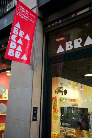 A pink Abracadabra banner outside a shop window. Barcelona, Spain, 2010.