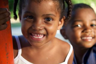 Two small girls smiling close to the camera. Barú, Colombia, 2011.