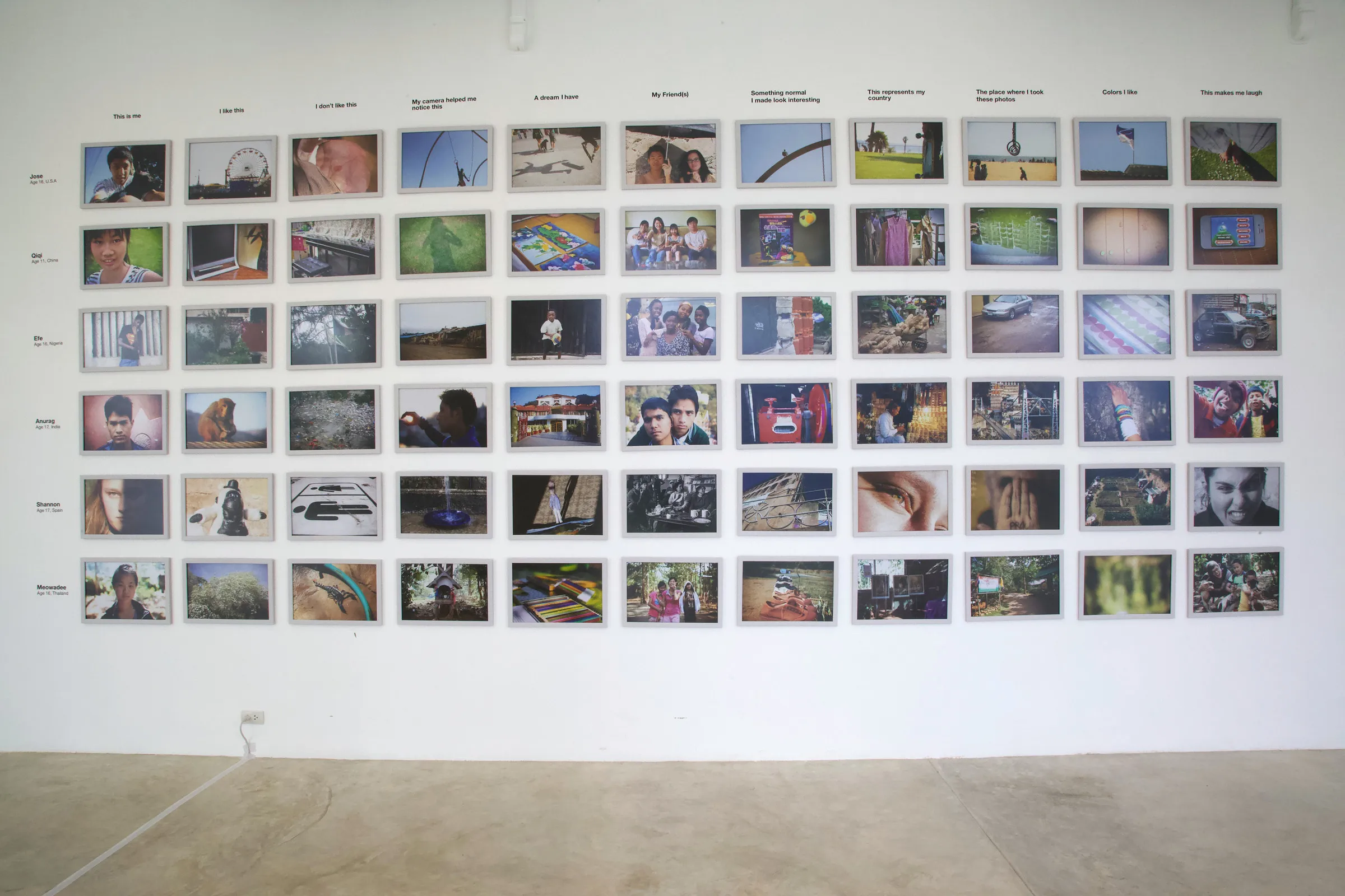 An exhibition wall of photographs in rows under printed task headings.