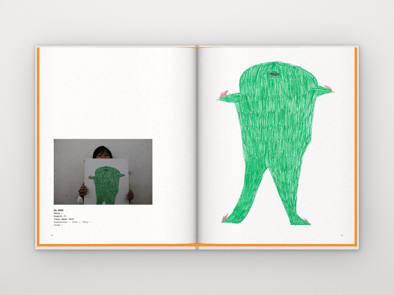 The book open on pages 20 and 21: a photo of Kodai holding his drawing, and his alien on a full page.